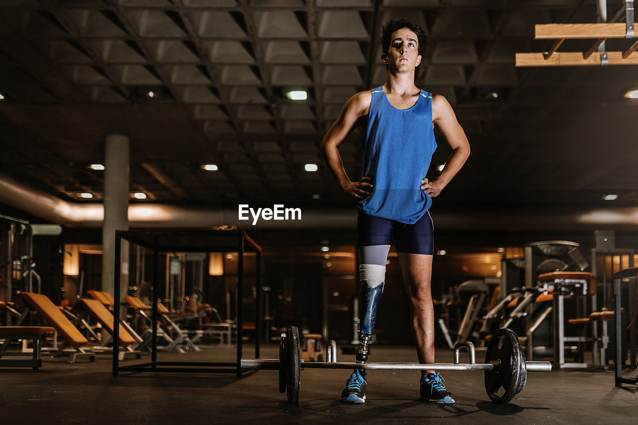 Man with artificial leg standing in gym