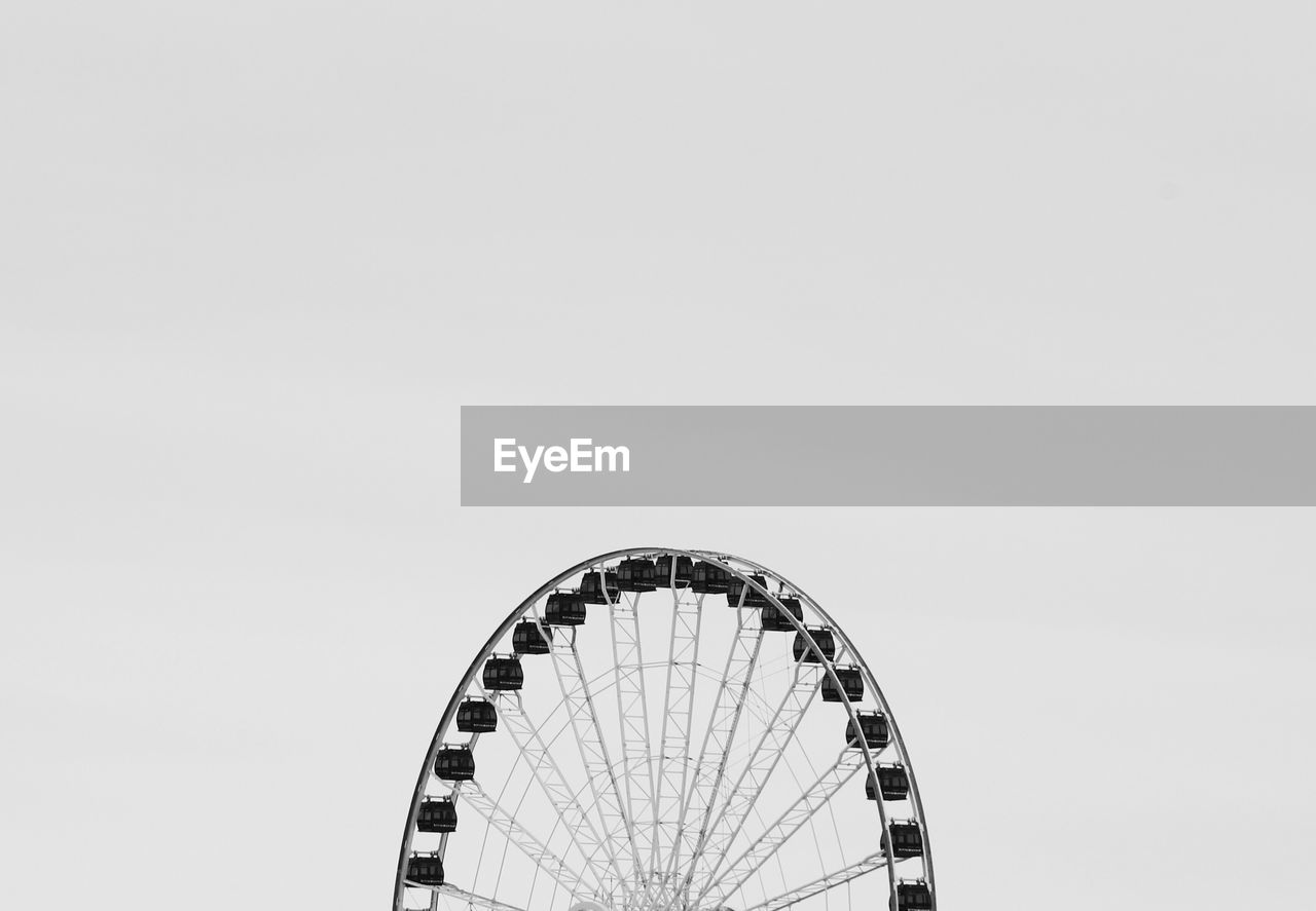 Low angle view of ferris wheel against clear sky