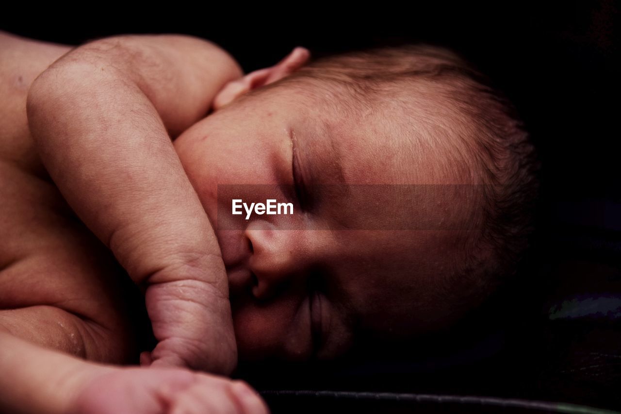 Close-up of baby sleeping on bed