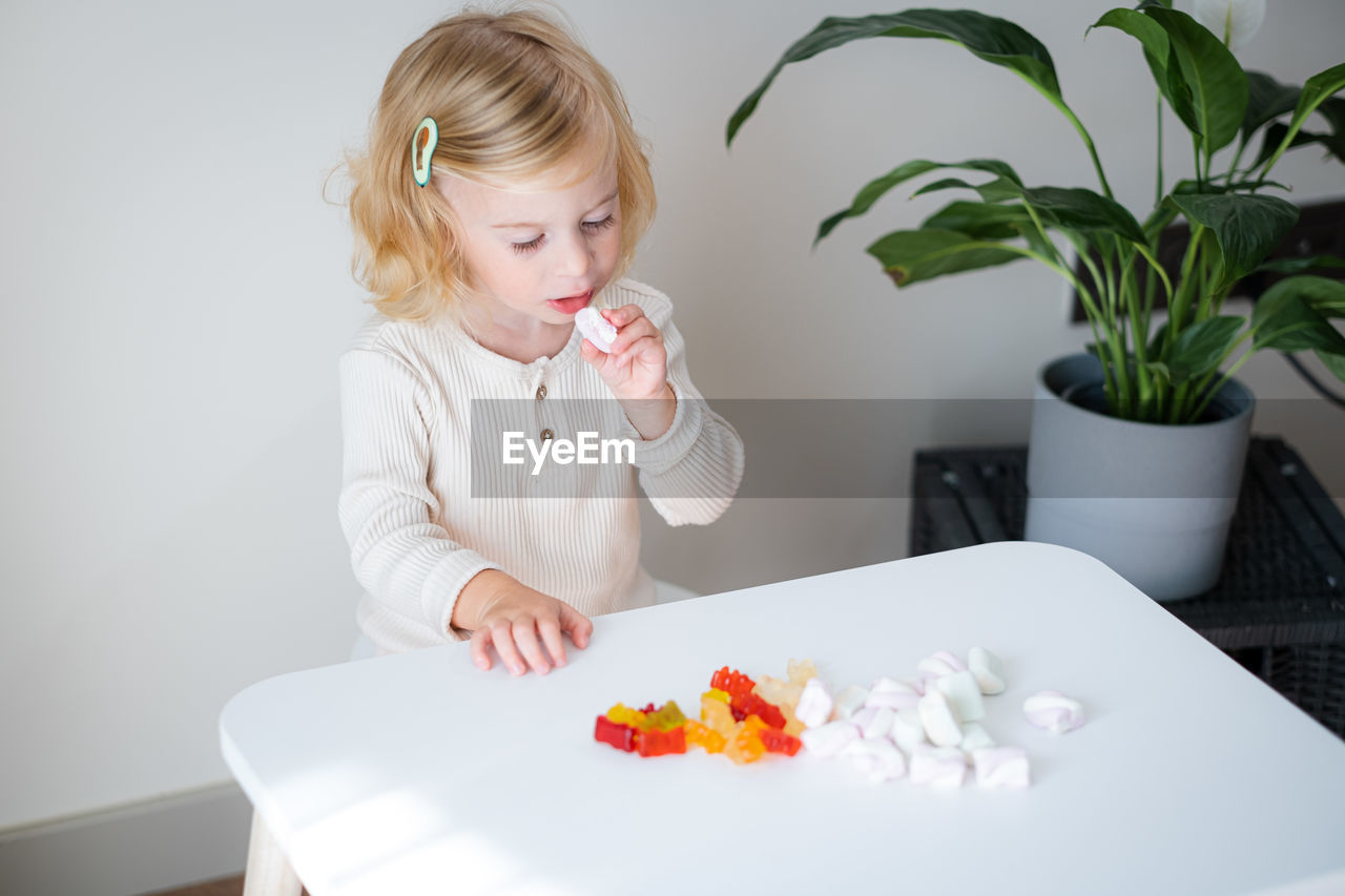 Portrait of cute girl eating sweets candy 