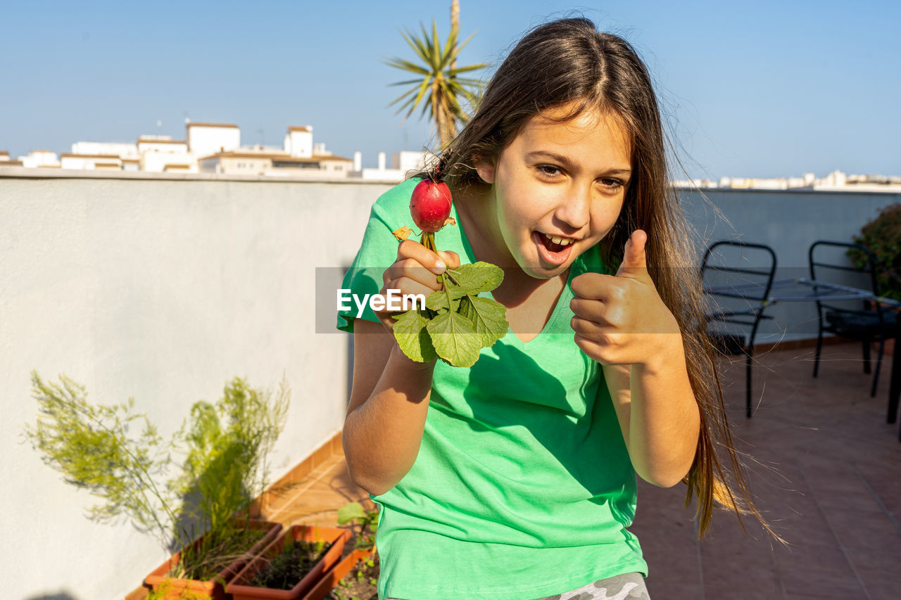 PORTRAIT OF HAPPY GIRL HOLDING FOOD