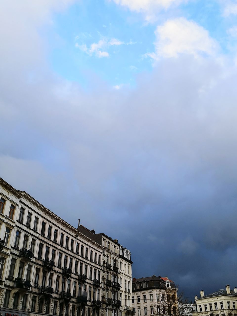 LOW ANGLE VIEW OF BUILDING AGAINST CLOUDY SKY