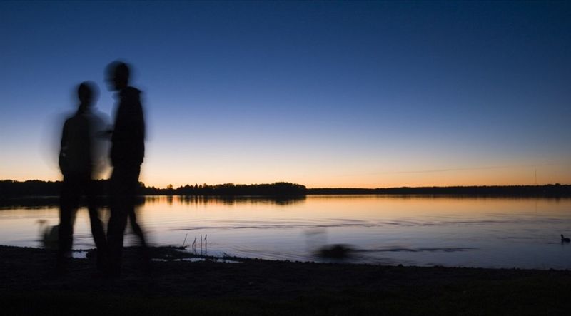 SILHOUETTE OF WOMAN STANDING BY LAKE