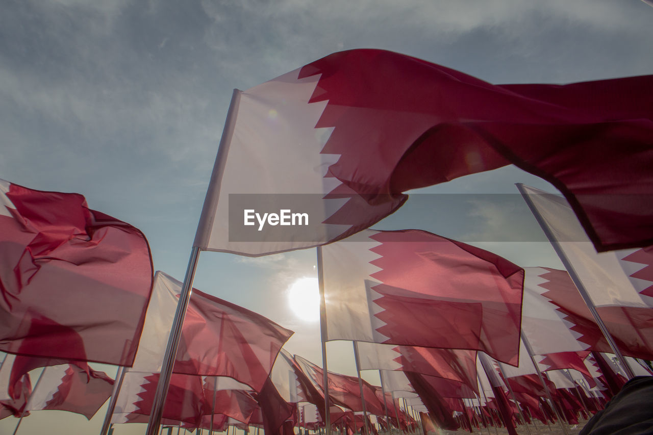 Low angle view of qatari flags against sky during qatar national day