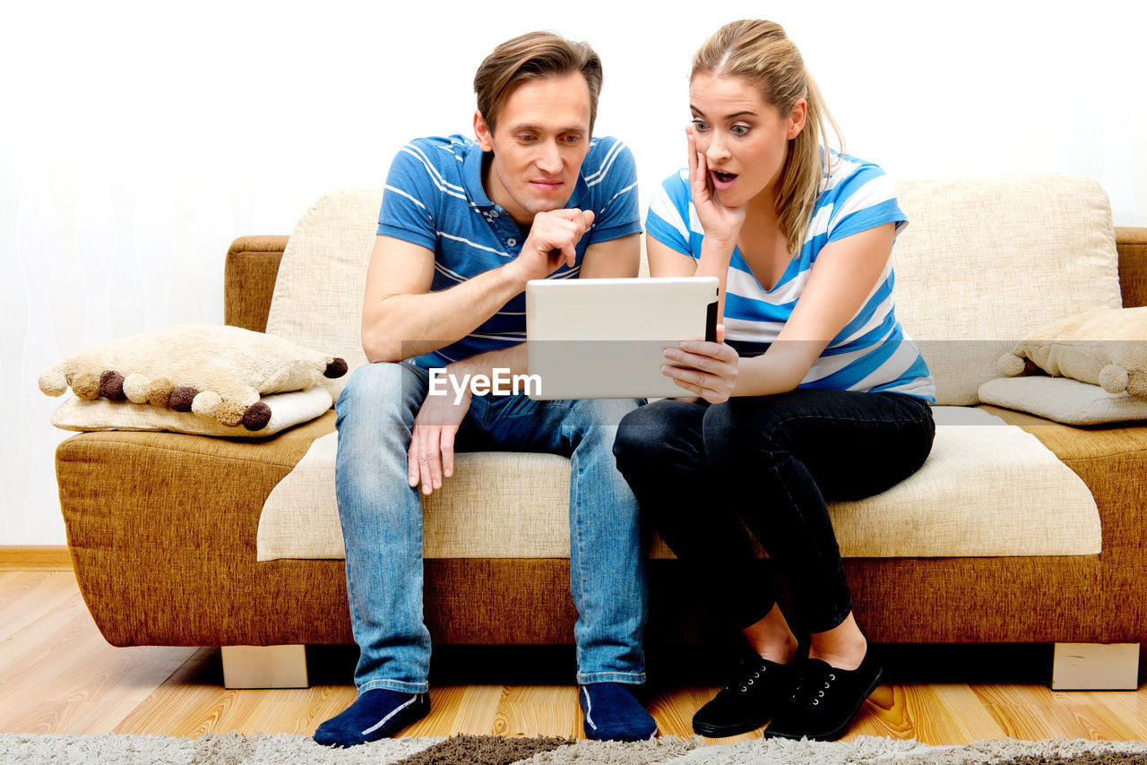 YOUNG MEN SITTING ON SOFA