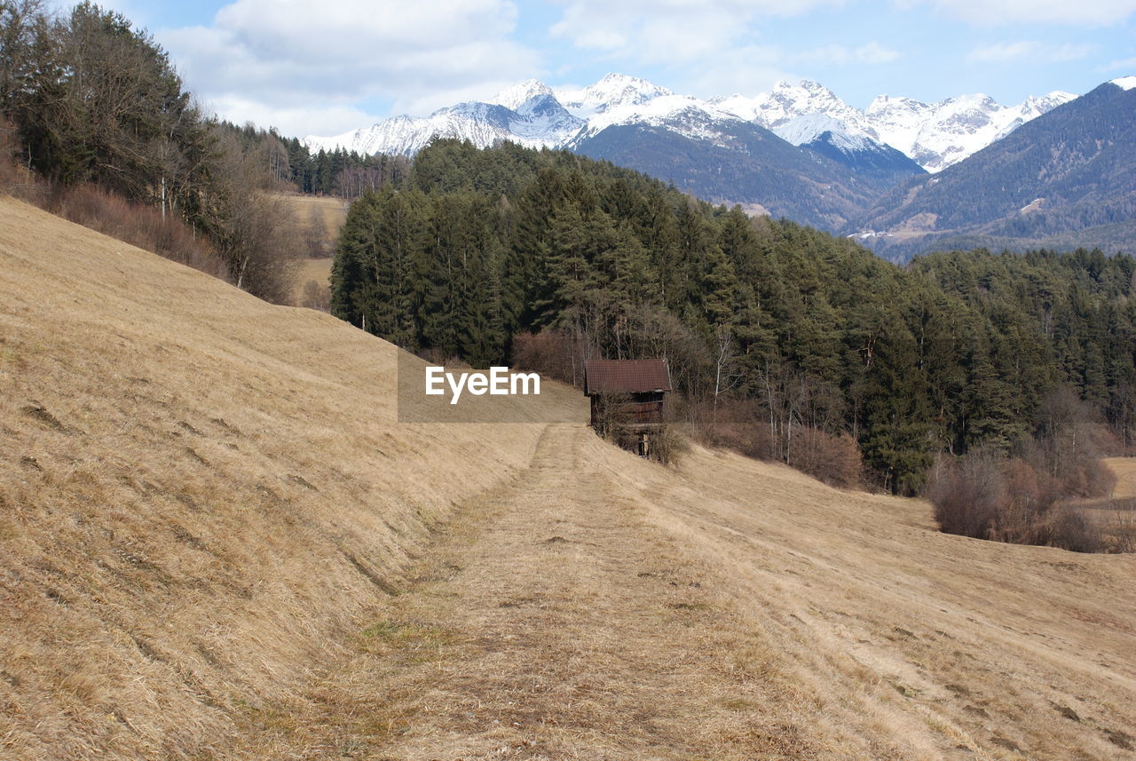 Scenic view of field and mountains against sky