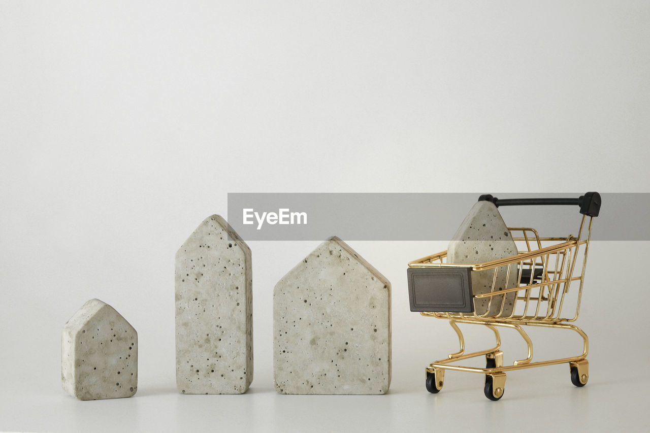 House model in mini shopping cart on the white background. buy a house. concept for property ladder
