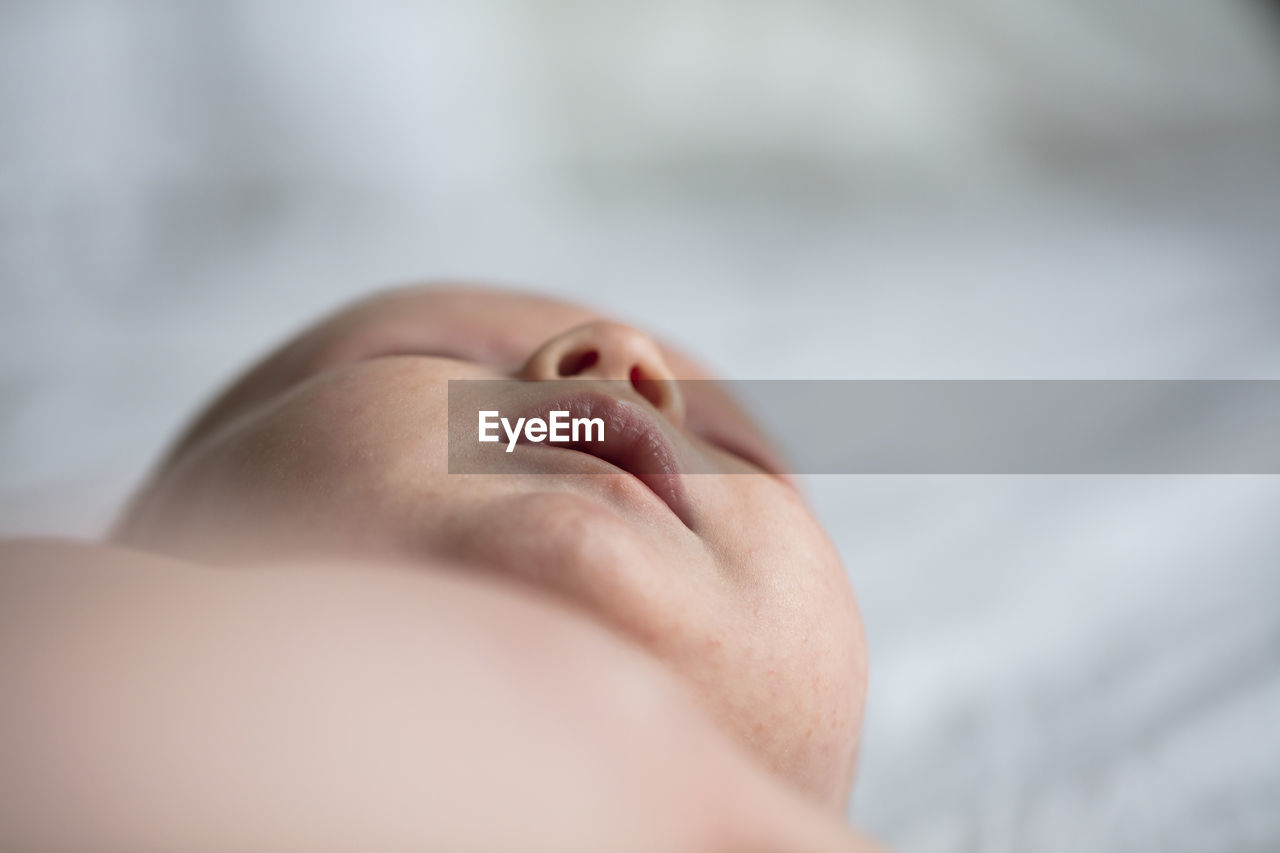 Close-up of baby lying on bed