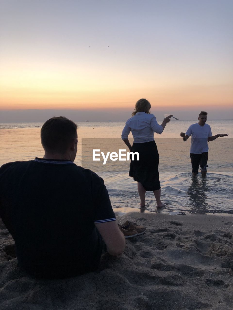 REAR VIEW OF PEOPLE ON BEACH