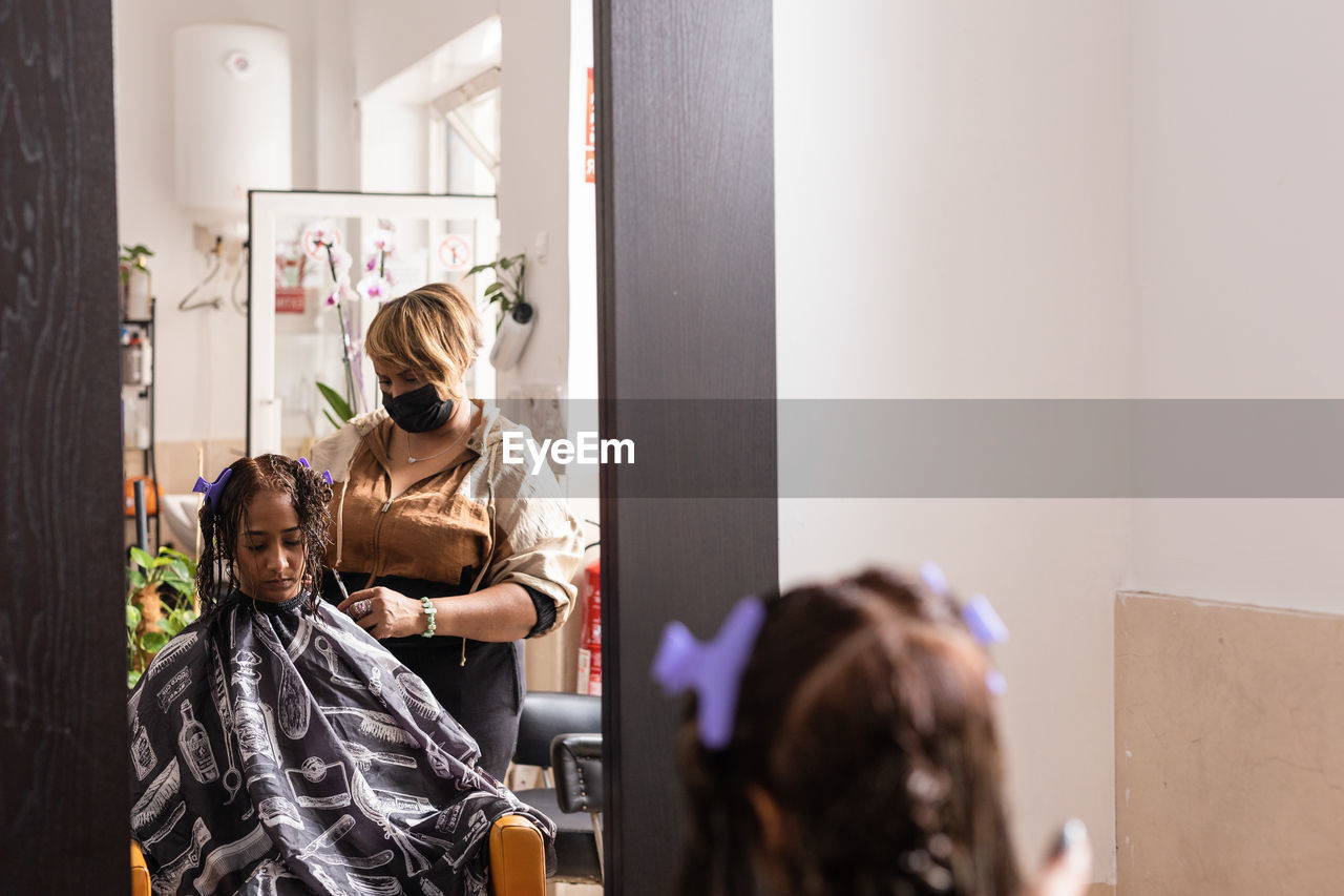 Hairdresser styling customer hair at salon