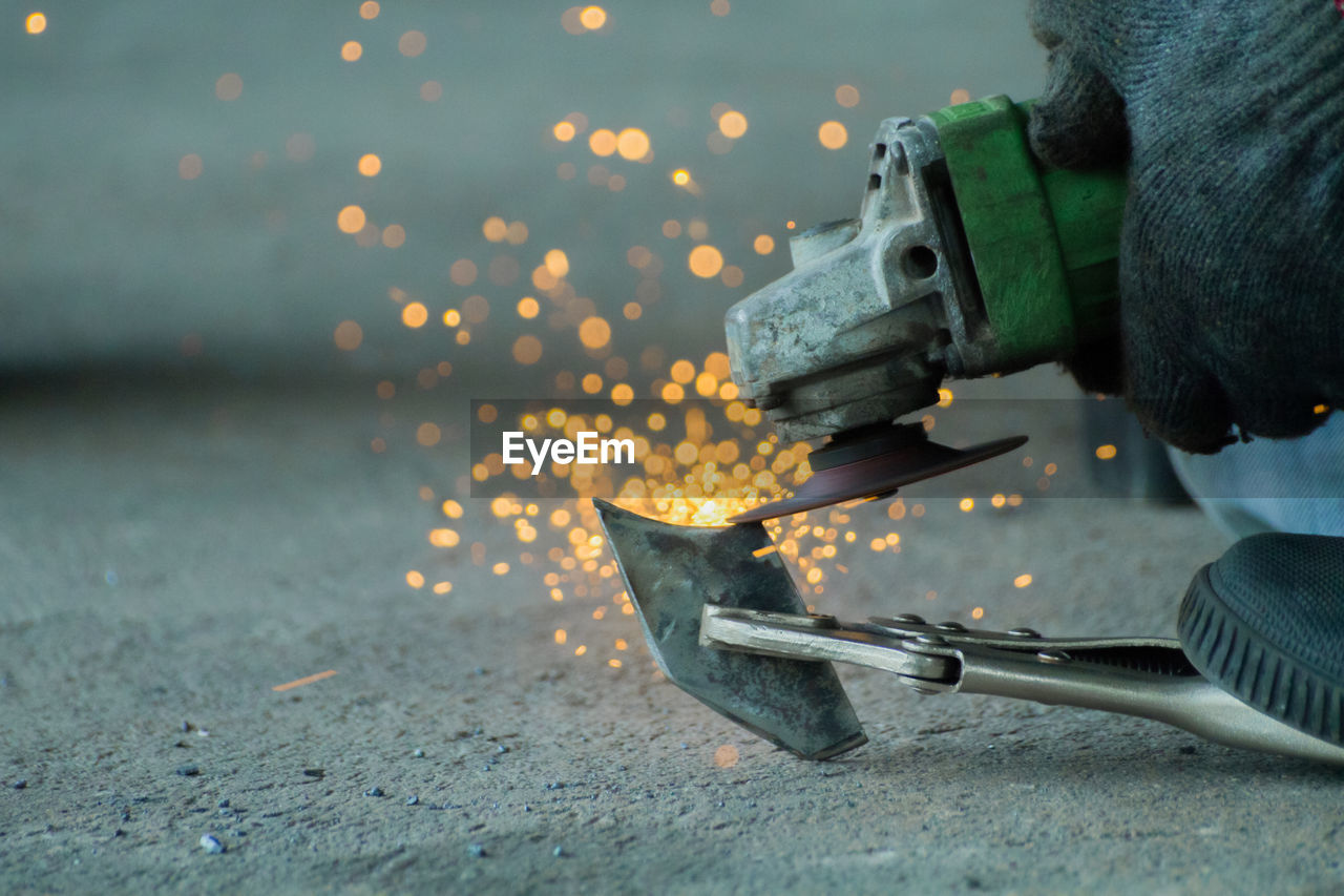 Cropped image of person molding shape of metal at workshop