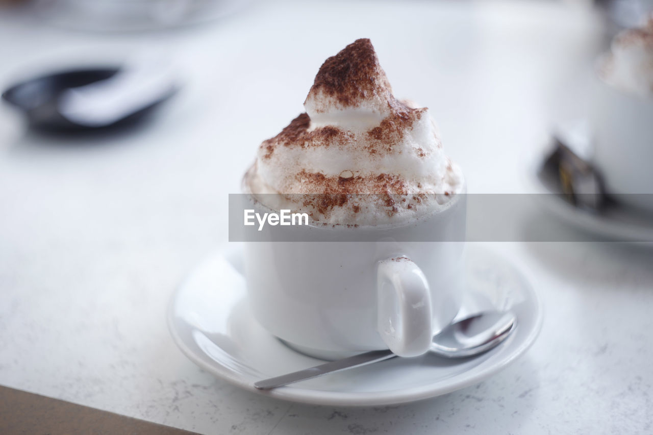 Close-up of coffee with froth in cup on table
