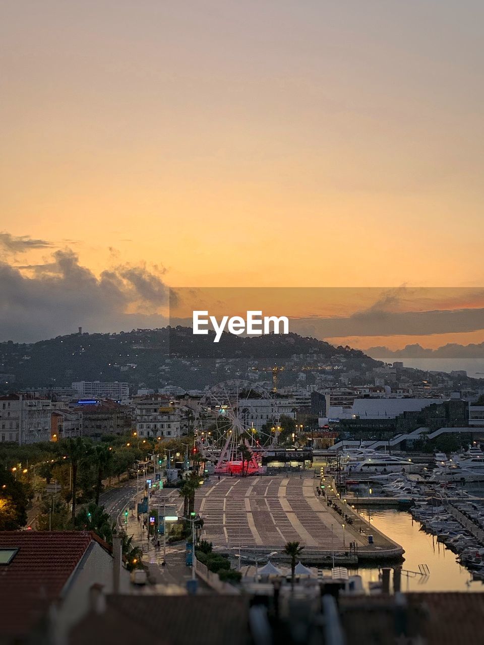 High angle view of street and buildings against sky during sunset