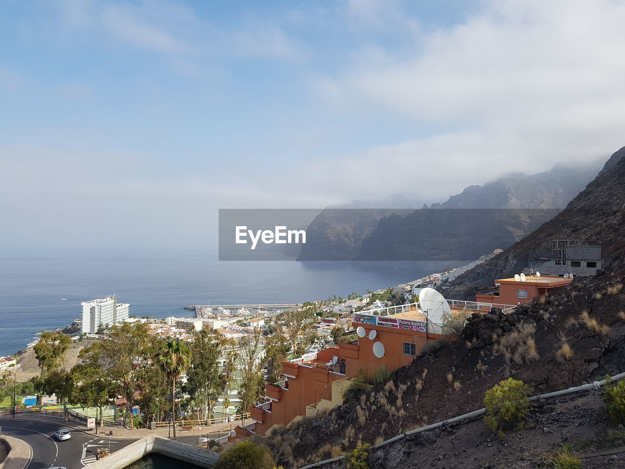 High angle view of town by sea against sky