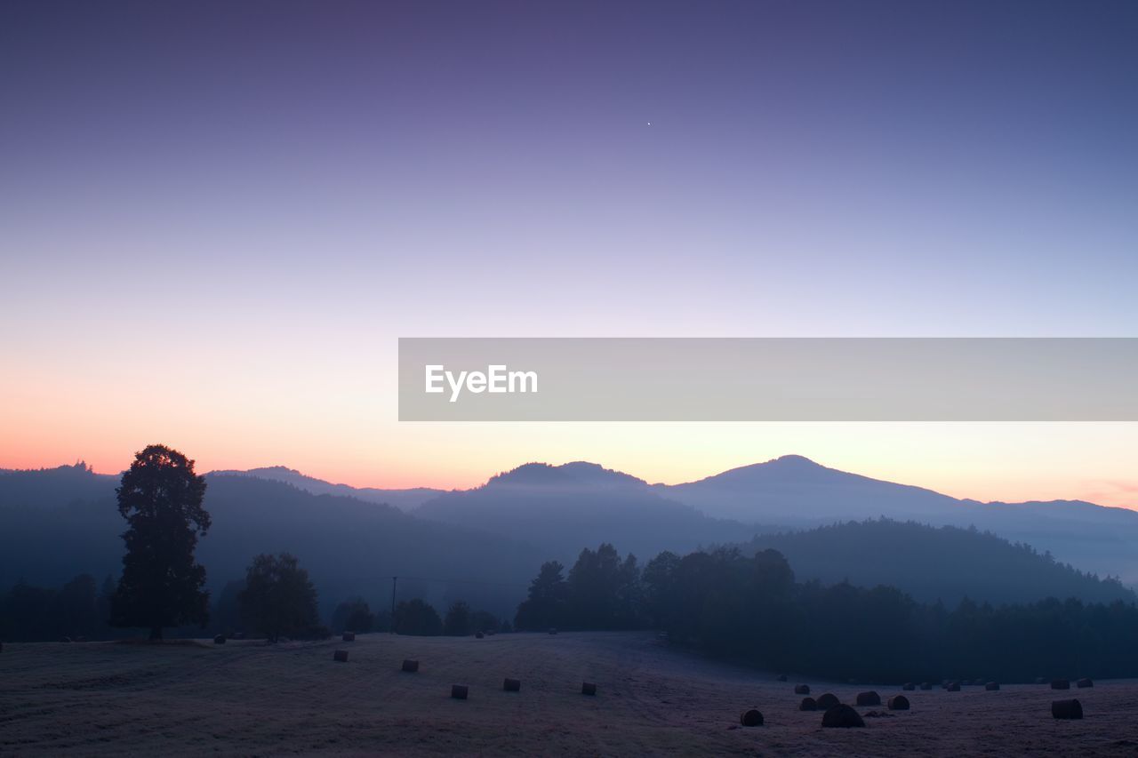 Picturesque misty sunrise in landscape. foggy morning meadow,