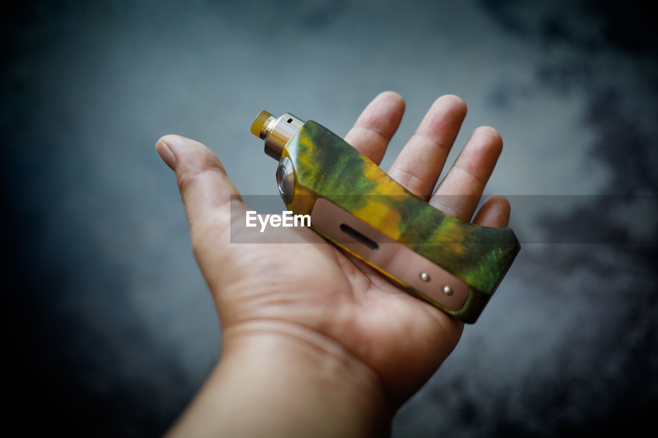 Cropped hand of person holding electronic cigarette