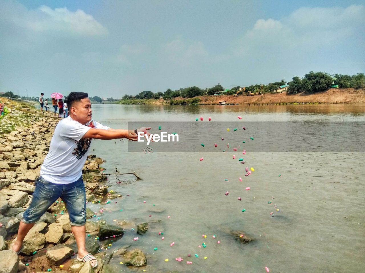 Man throwing food in lake