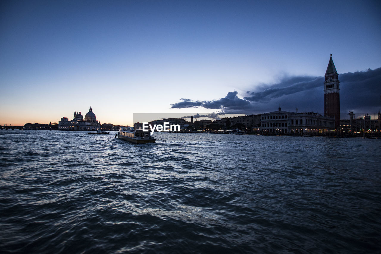 Boats in san marco canal at st marks square against sky during sunset