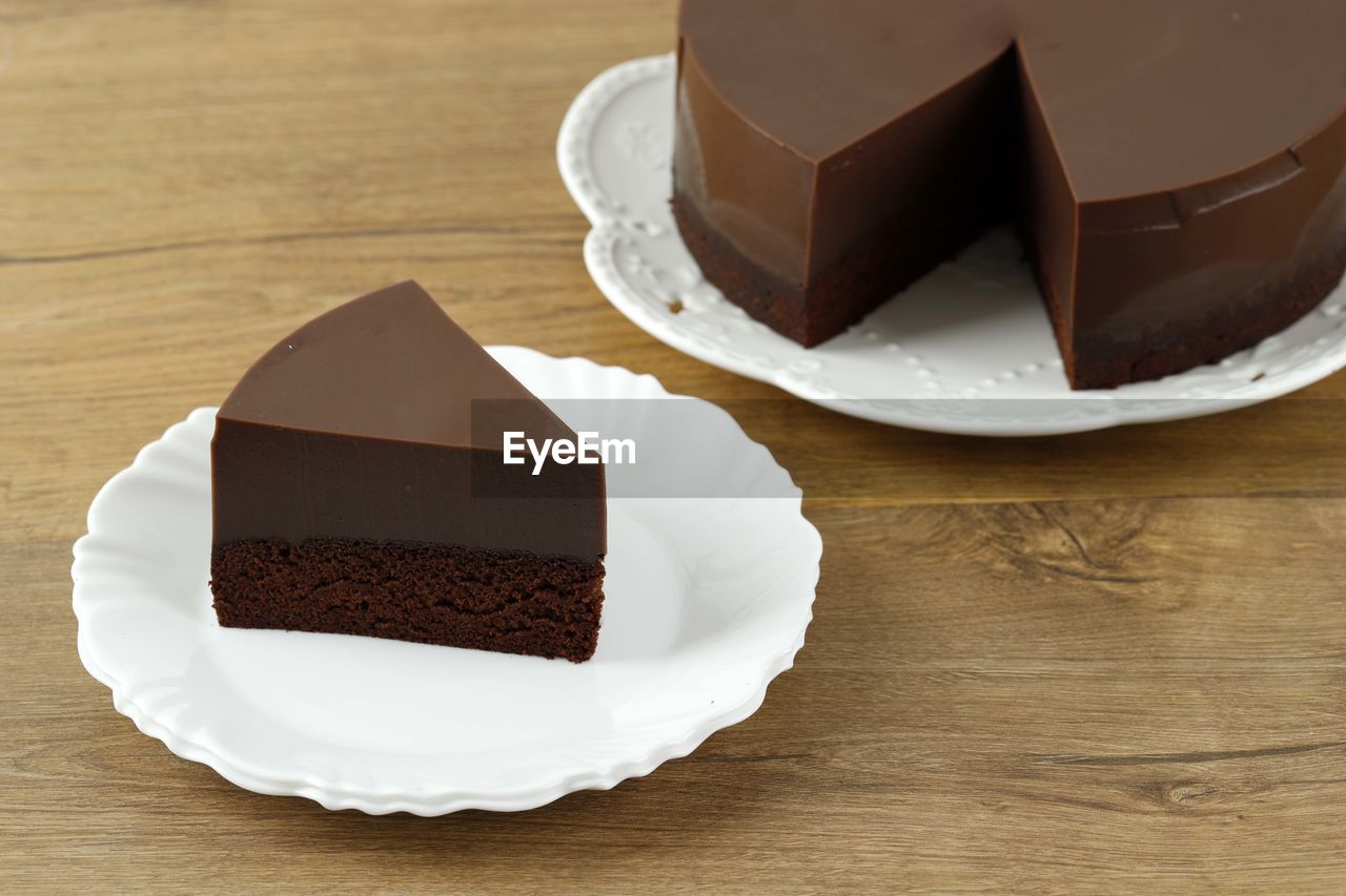 Slice of homemade chocolate two layer brownie pudding on wooden table, copy space