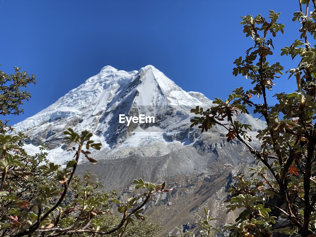 LOW ANGLE VIEW OF SNOWCAPPED MOUNTAIN AGAINST CLEAR SKY