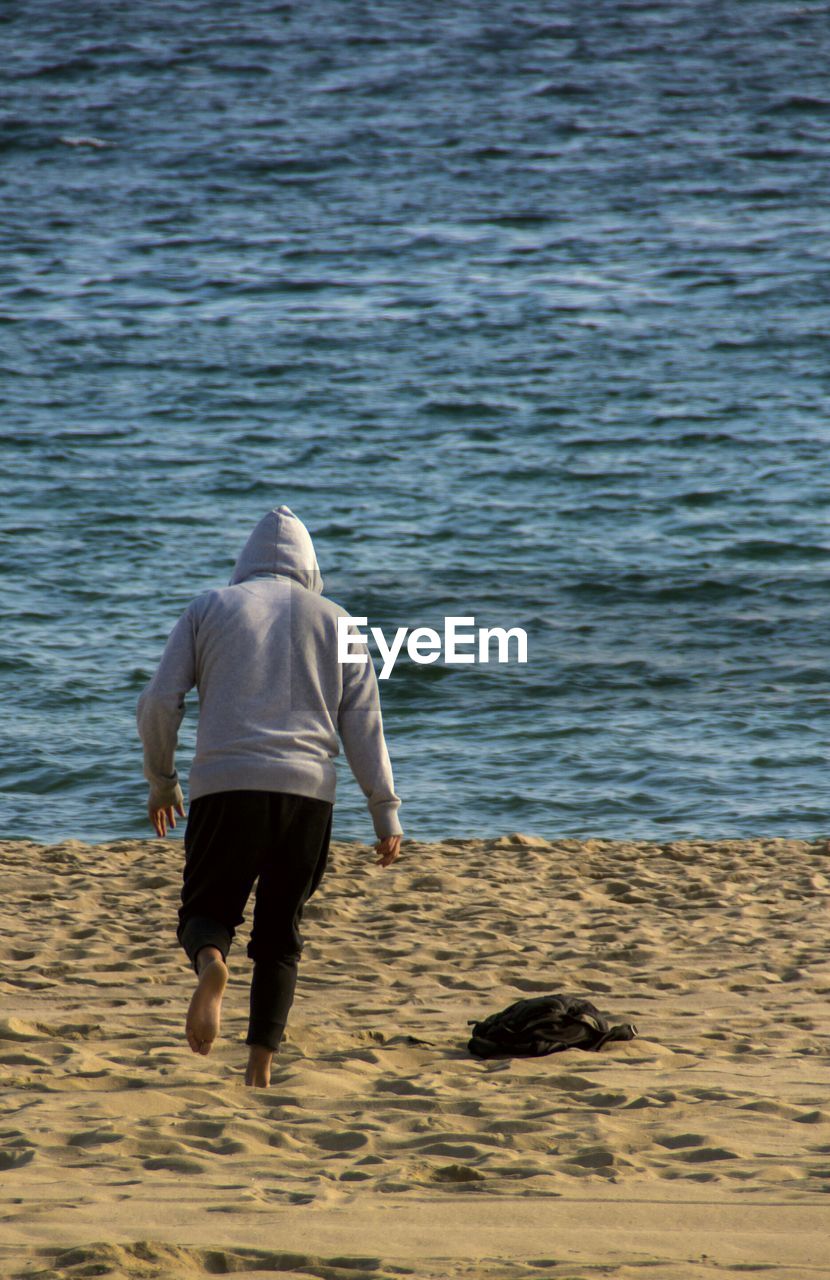 YOUNG WOMAN STANDING ON SHORE