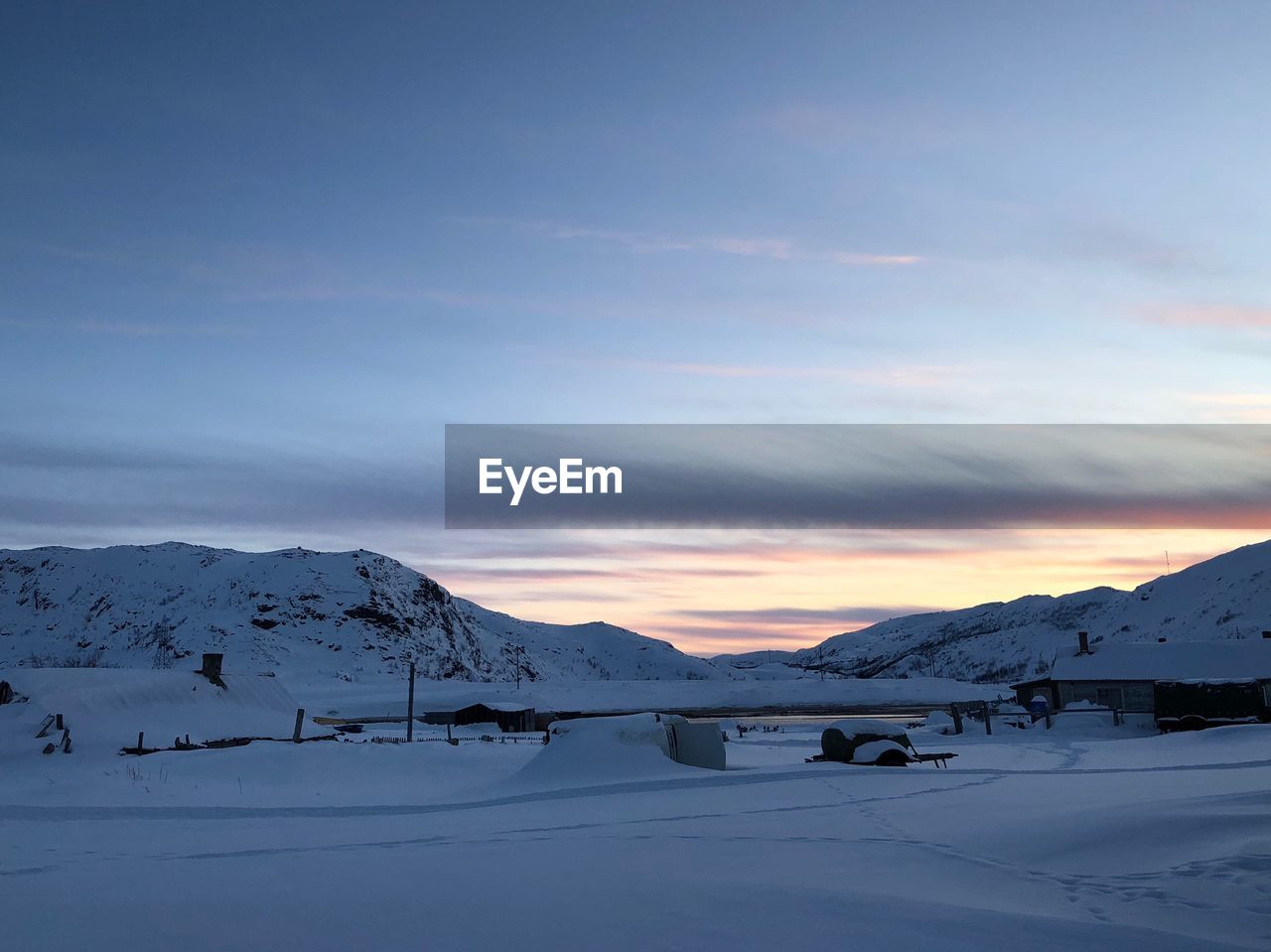 Scenic view of snow covered mountains against sky during sunset