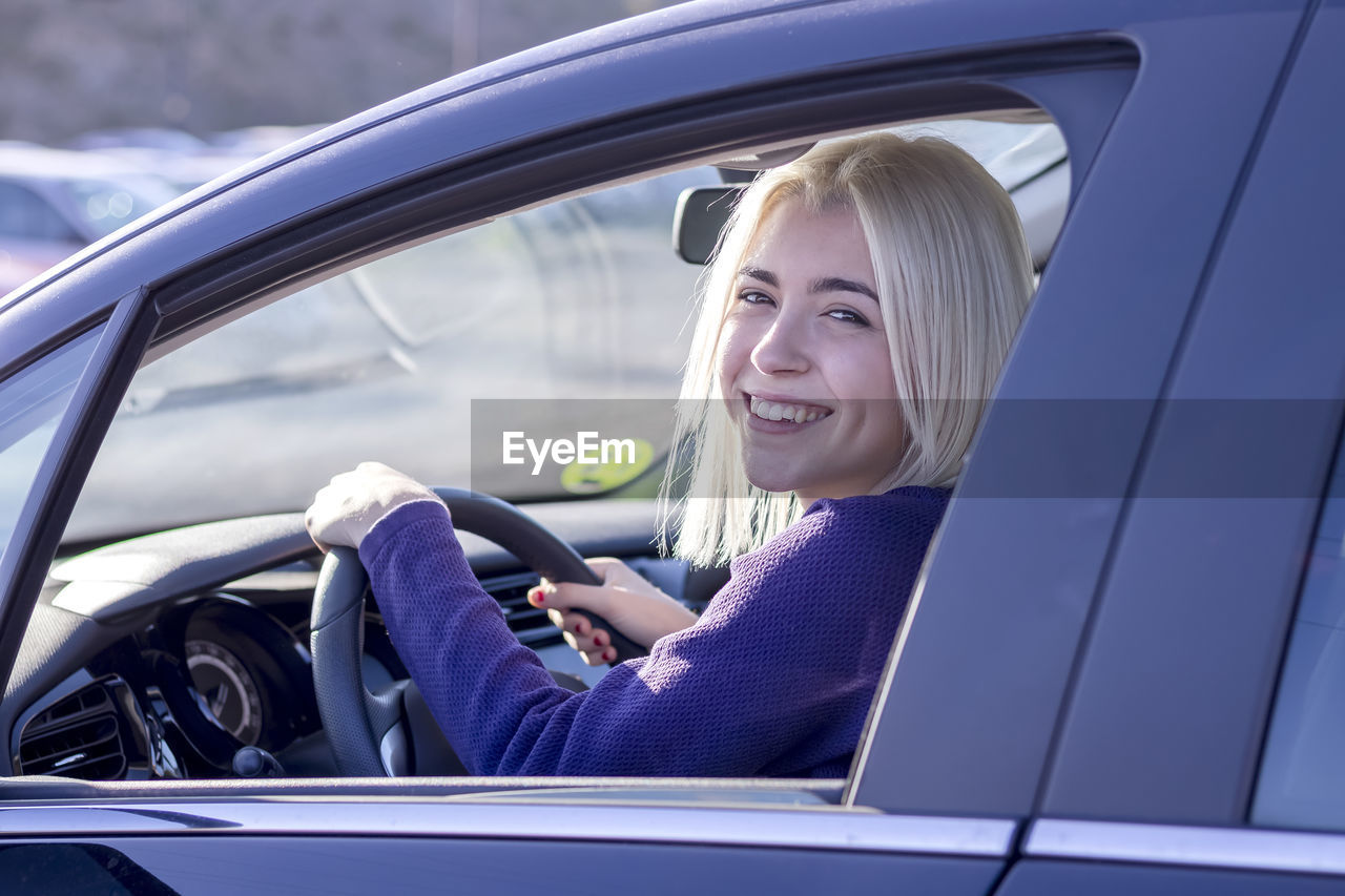 portrait of smiling woman in car