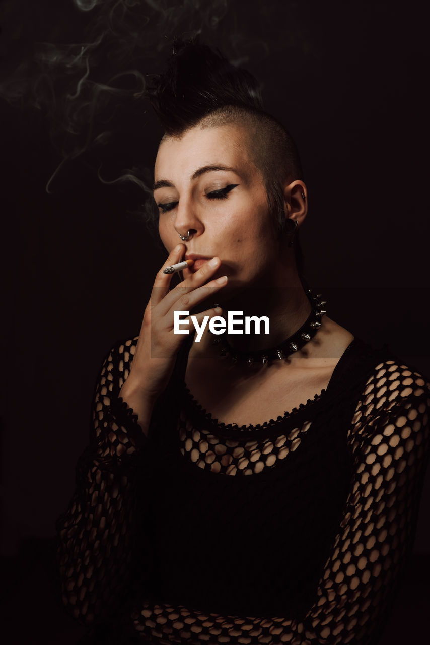 Adult female with mohawk and piercing smoking cigarette