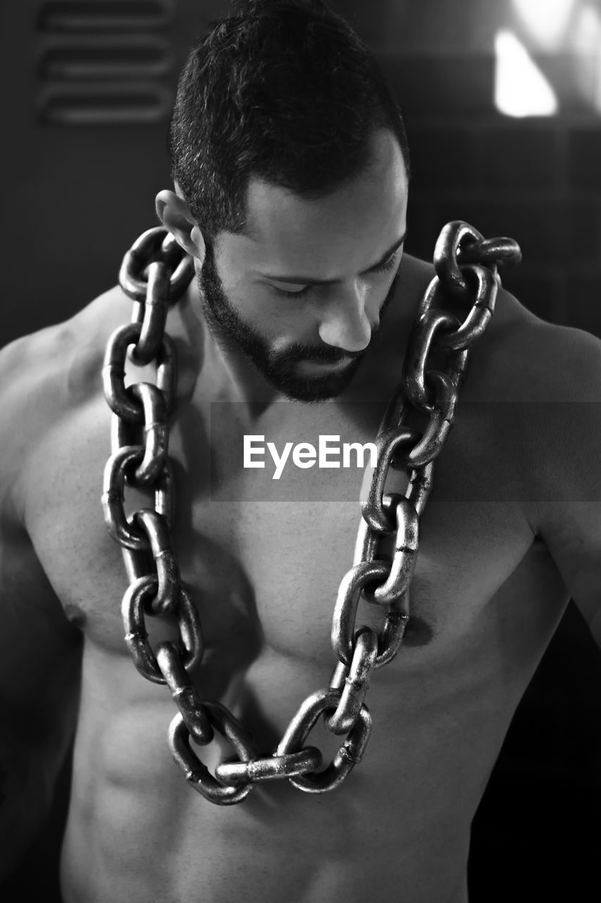 PORTRAIT OF SHIRTLESS YOUNG MAN WITH CHAIN