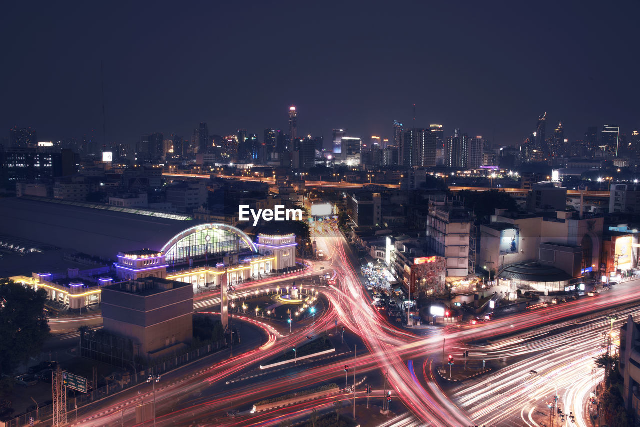 High angle view of illuminated street amidst buildings in city at night