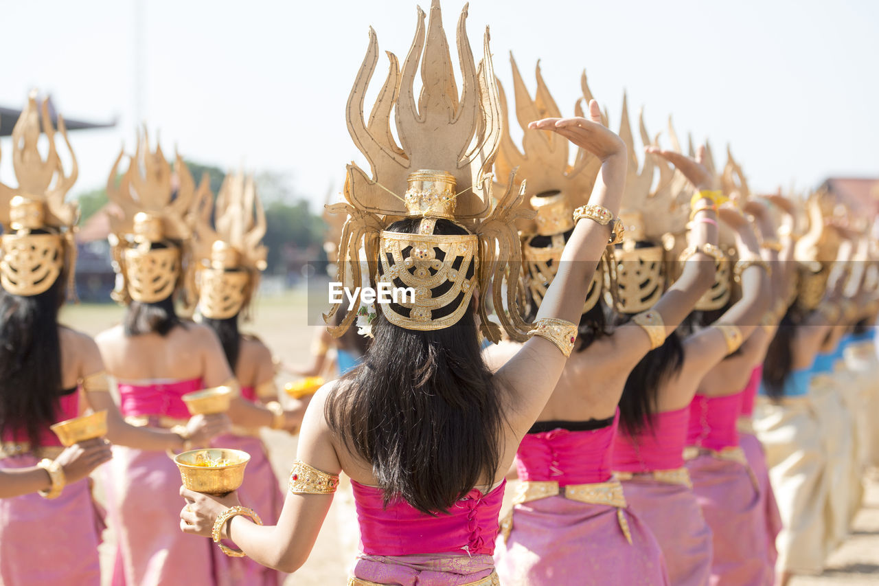 Rear view of women wearing costumes dancing at event