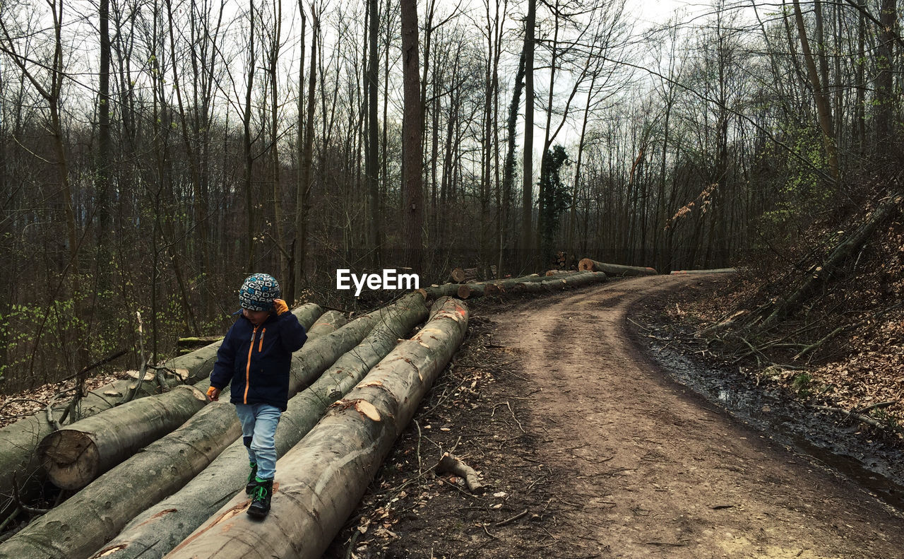 Kid walking on log in forest