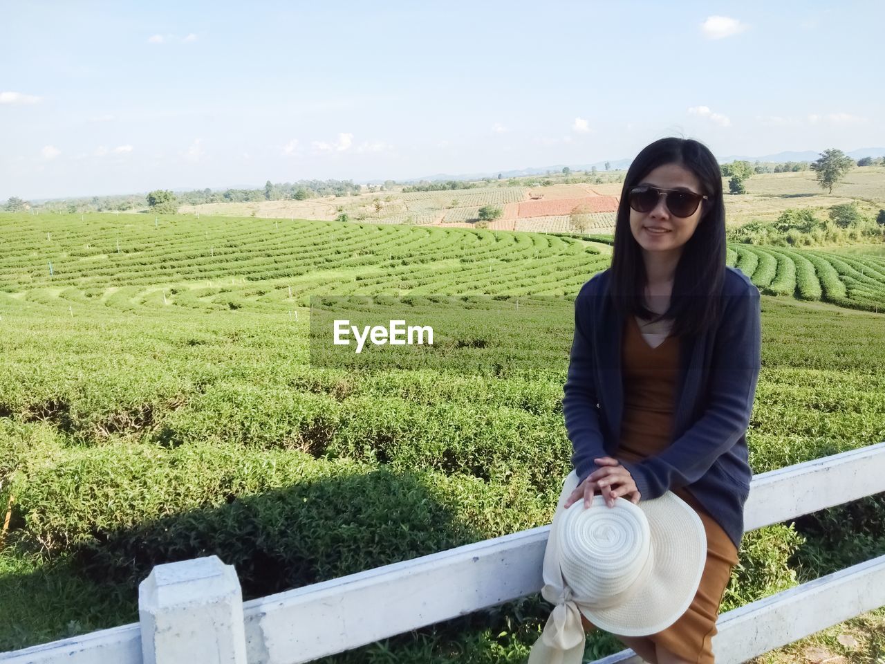 PORTRAIT OF BEAUTIFUL YOUNG WOMAN STANDING ON FIELD