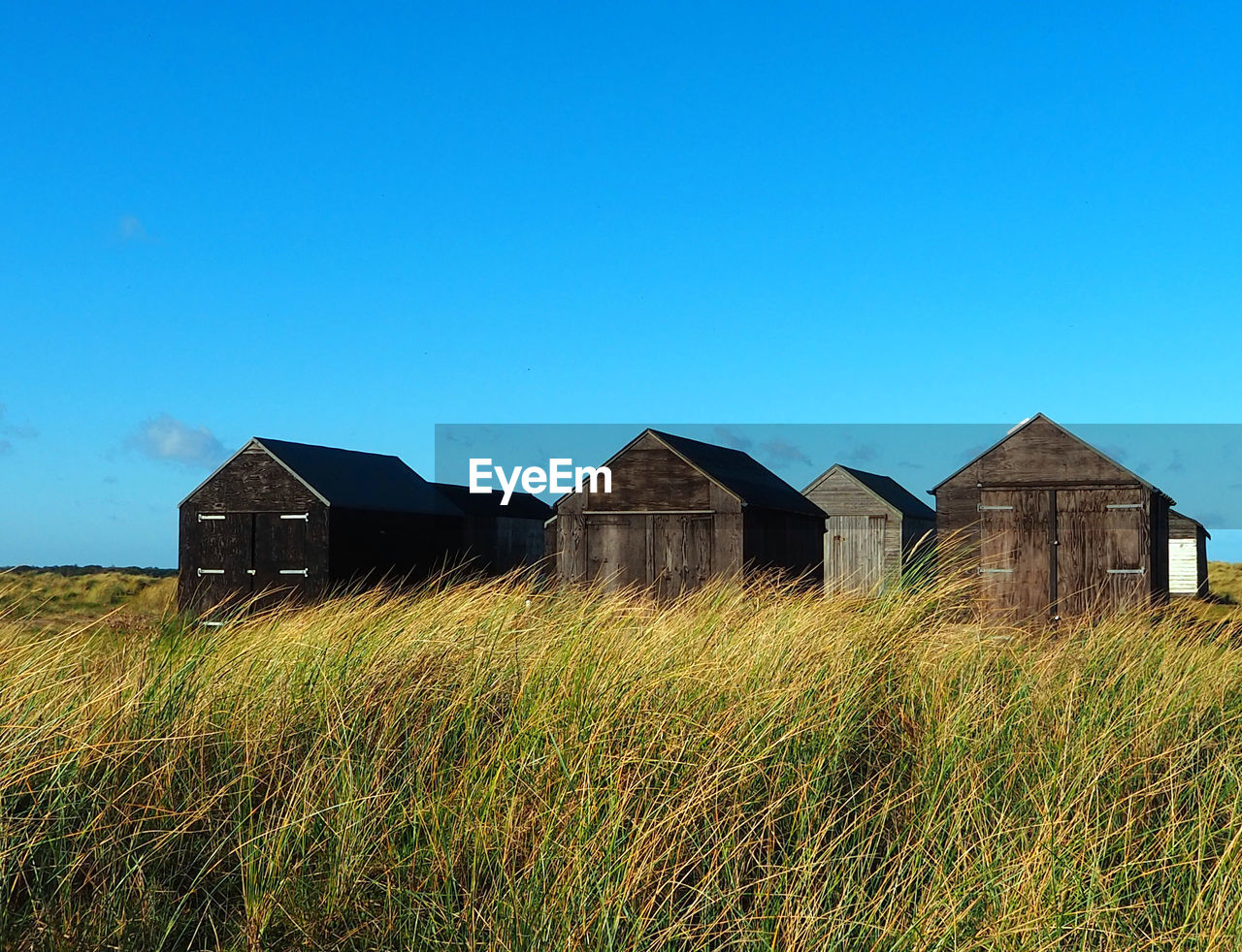 BARN ON FIELD AGAINST SKY