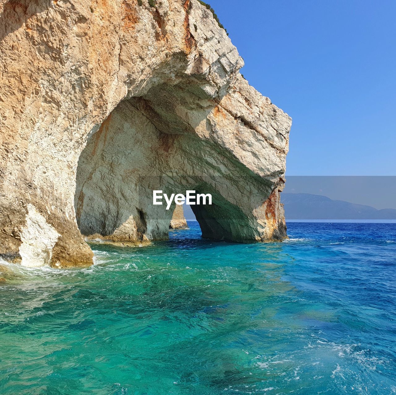 Rock formation in sea against sky