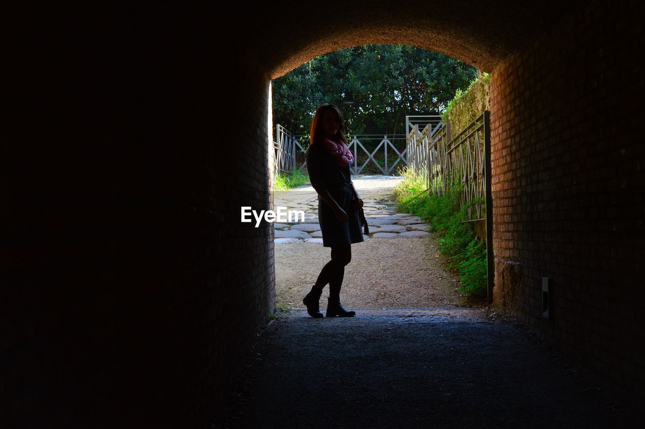 Woman standing in tunnel at park