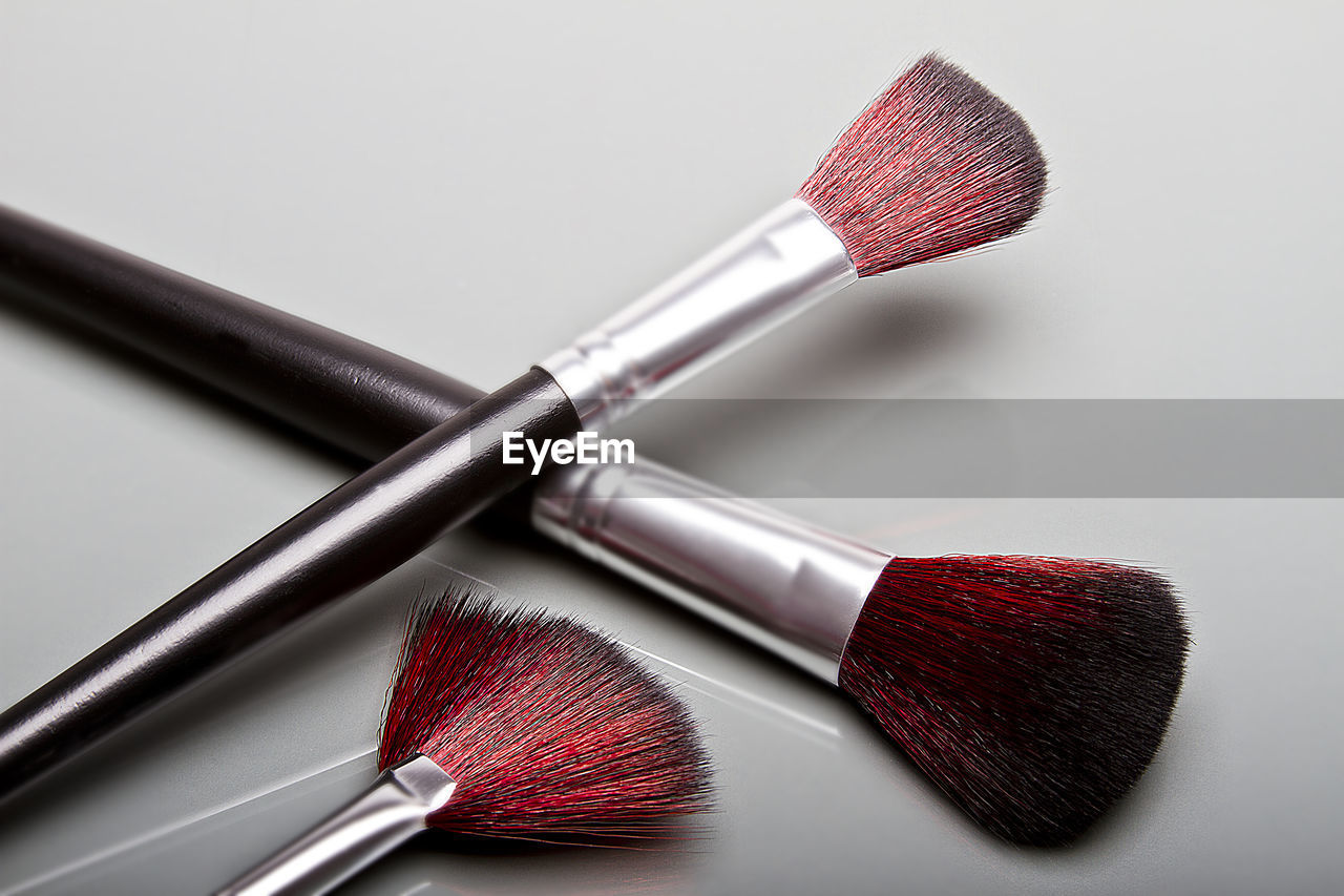 High angle view of make-up brushes on gray background