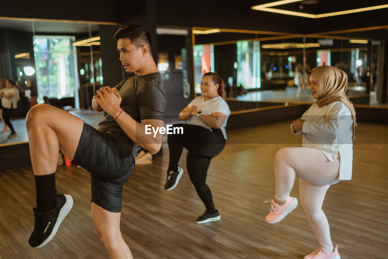 side view of friends exercising at gym