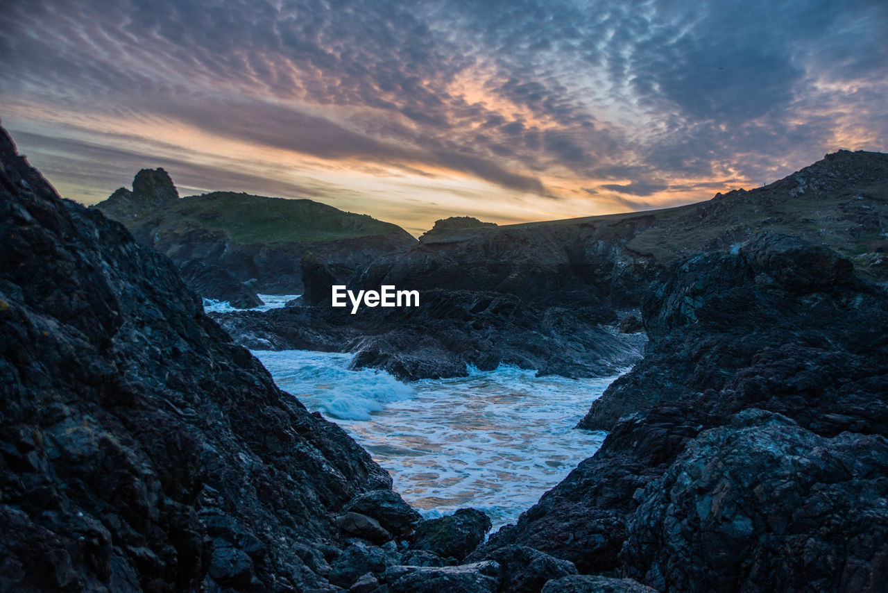 Scenic view of mountains against sky during sunset at kynance cove