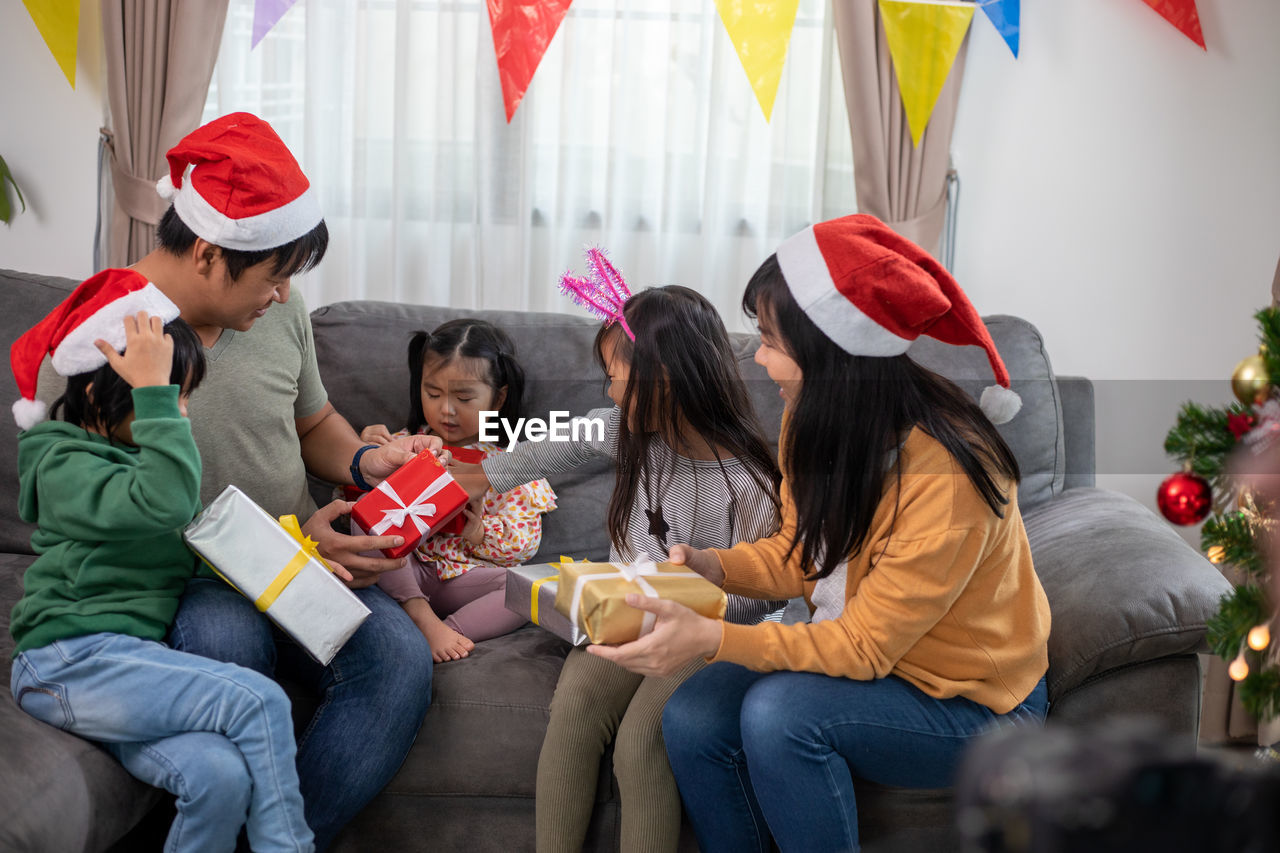 portrait of smiling friends using digital tablet while sitting at home