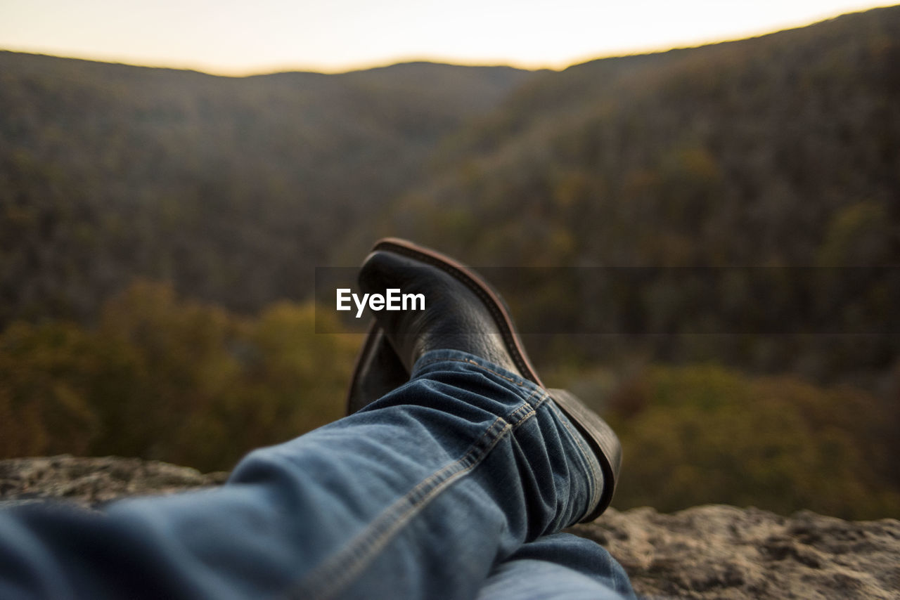 Low section of man resting against mountain