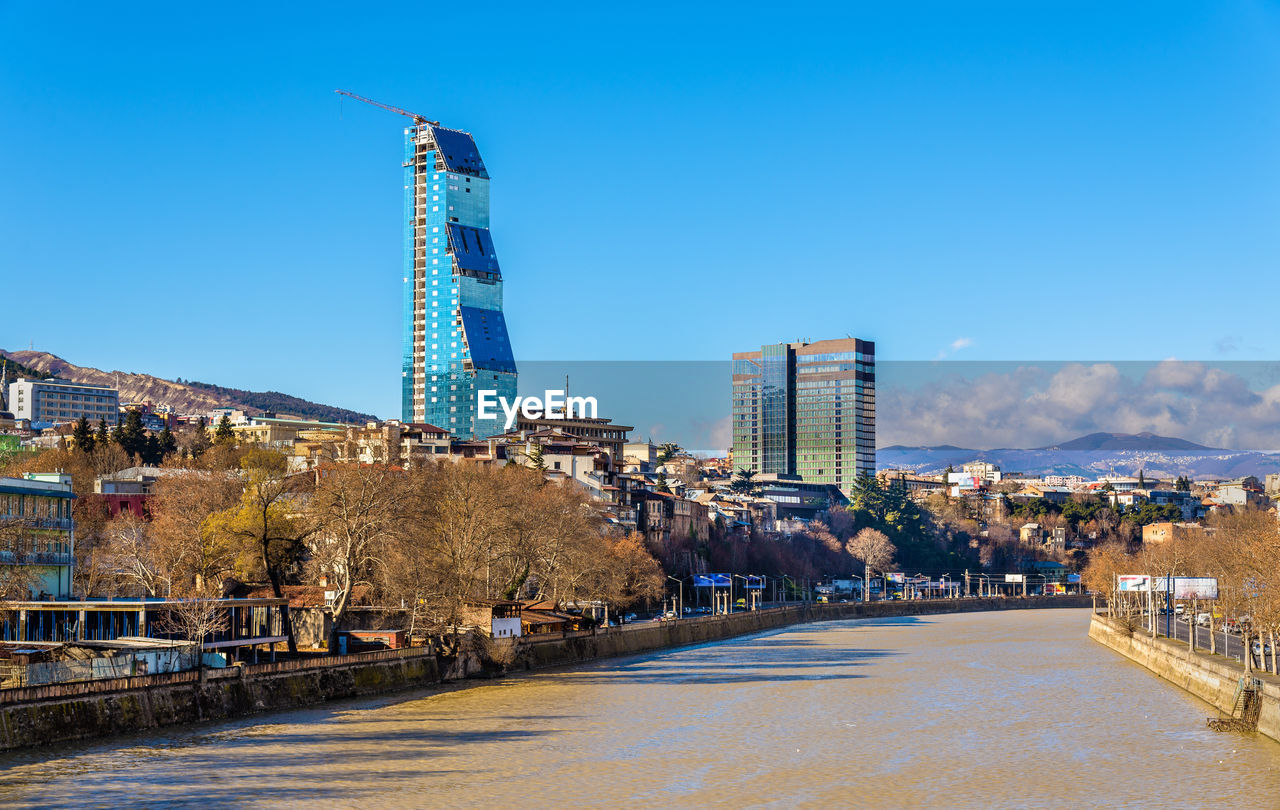 TOWER AMIDST BUILDINGS AGAINST SKY