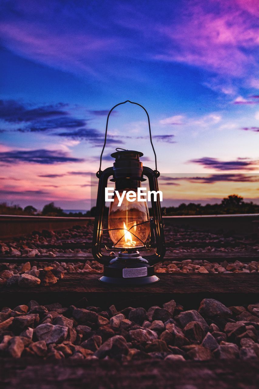 Lantern and stones against sky