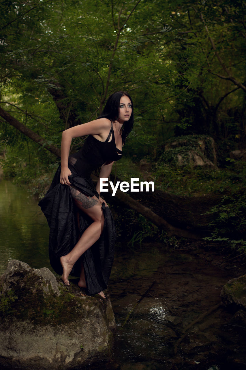 Beautiful woman looking away in forest