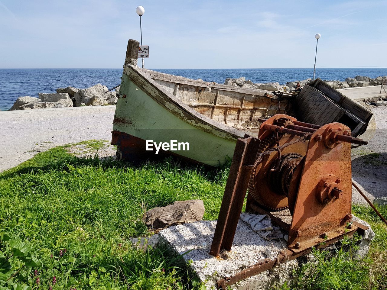 Abandoned boat on beach against sky