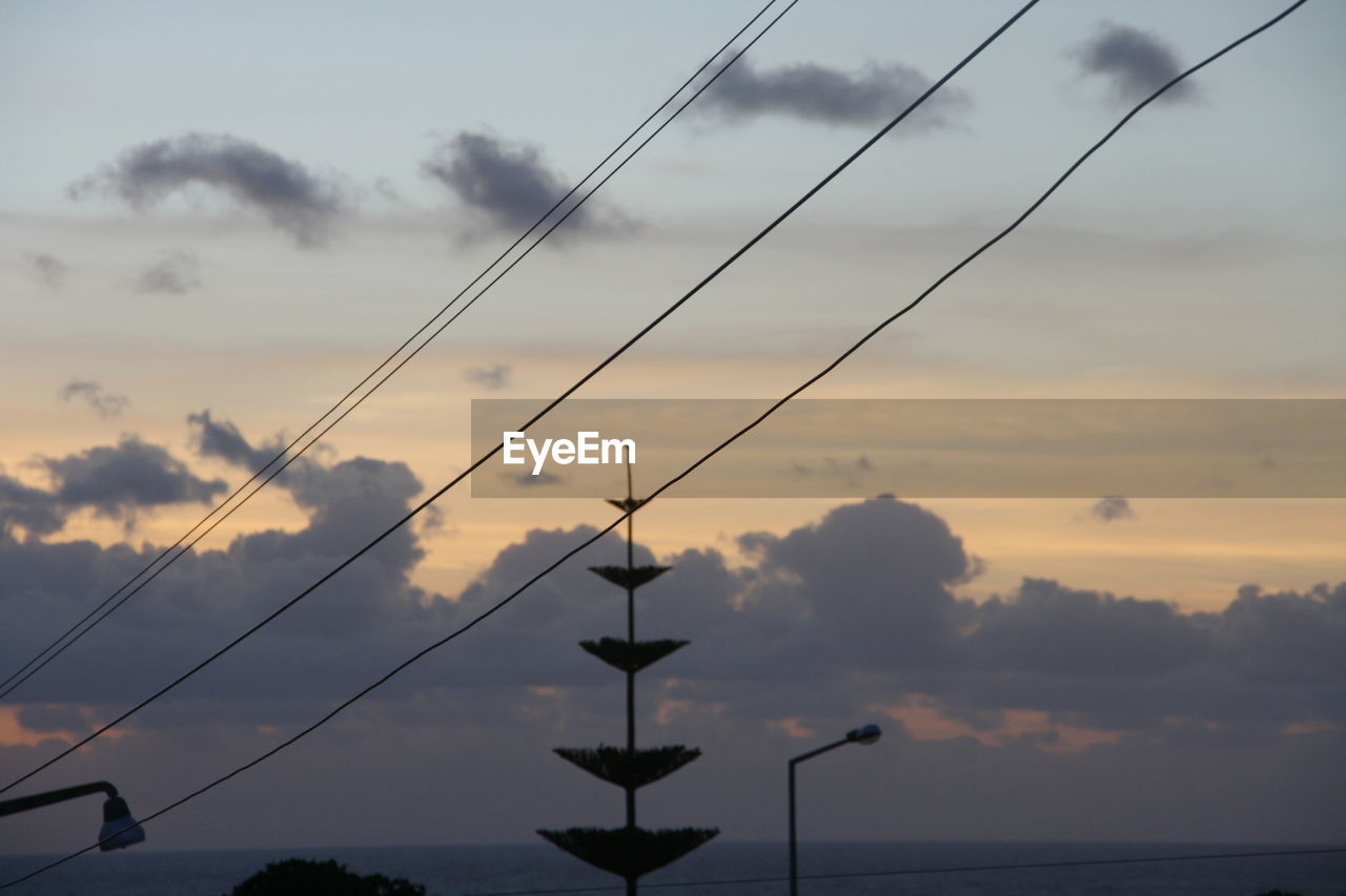 LOW ANGLE VIEW OF ELECTRICITY PYLON AGAINST SKY DURING SUNSET