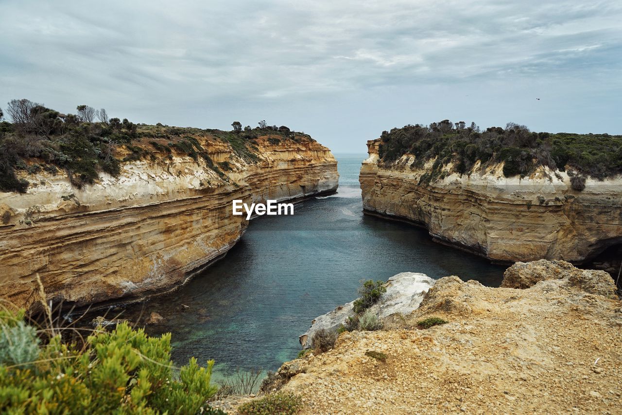 Rock formations by sea against sky