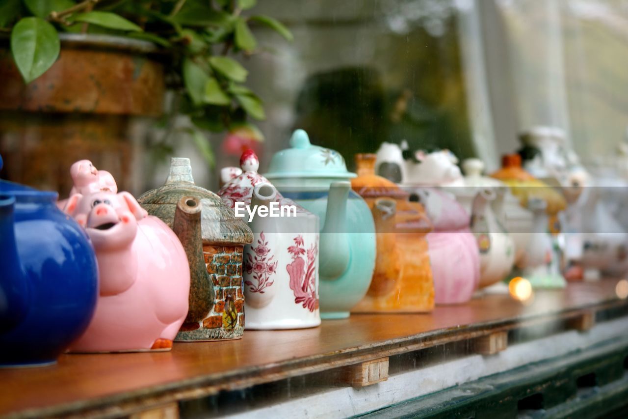 Close-up of teapots on rack at store