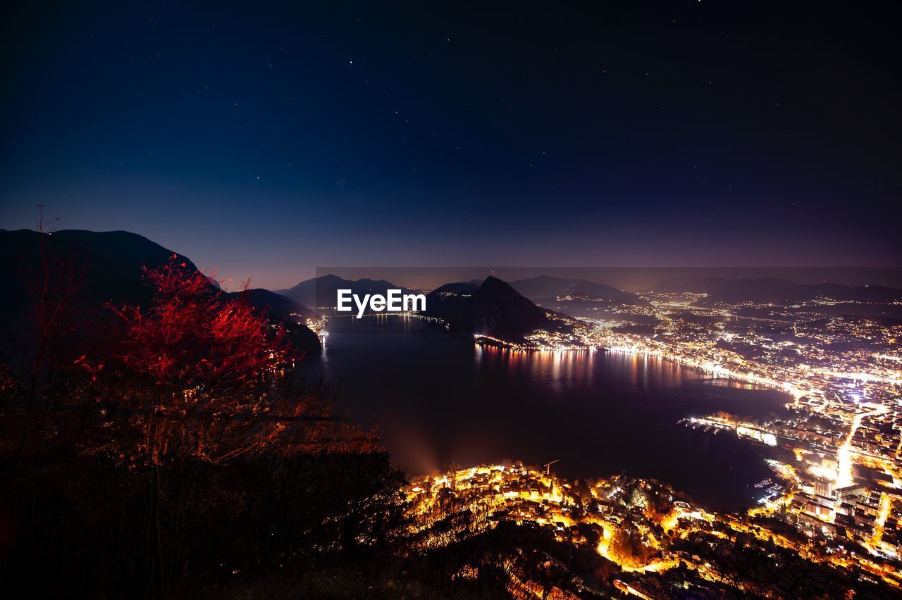 Illuminated cityscape against sky at night