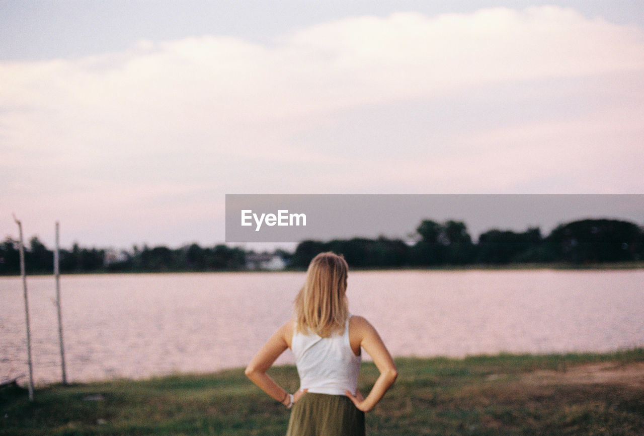 REAR VIEW OF WOMAN LOOKING AT VIEW OF SKY